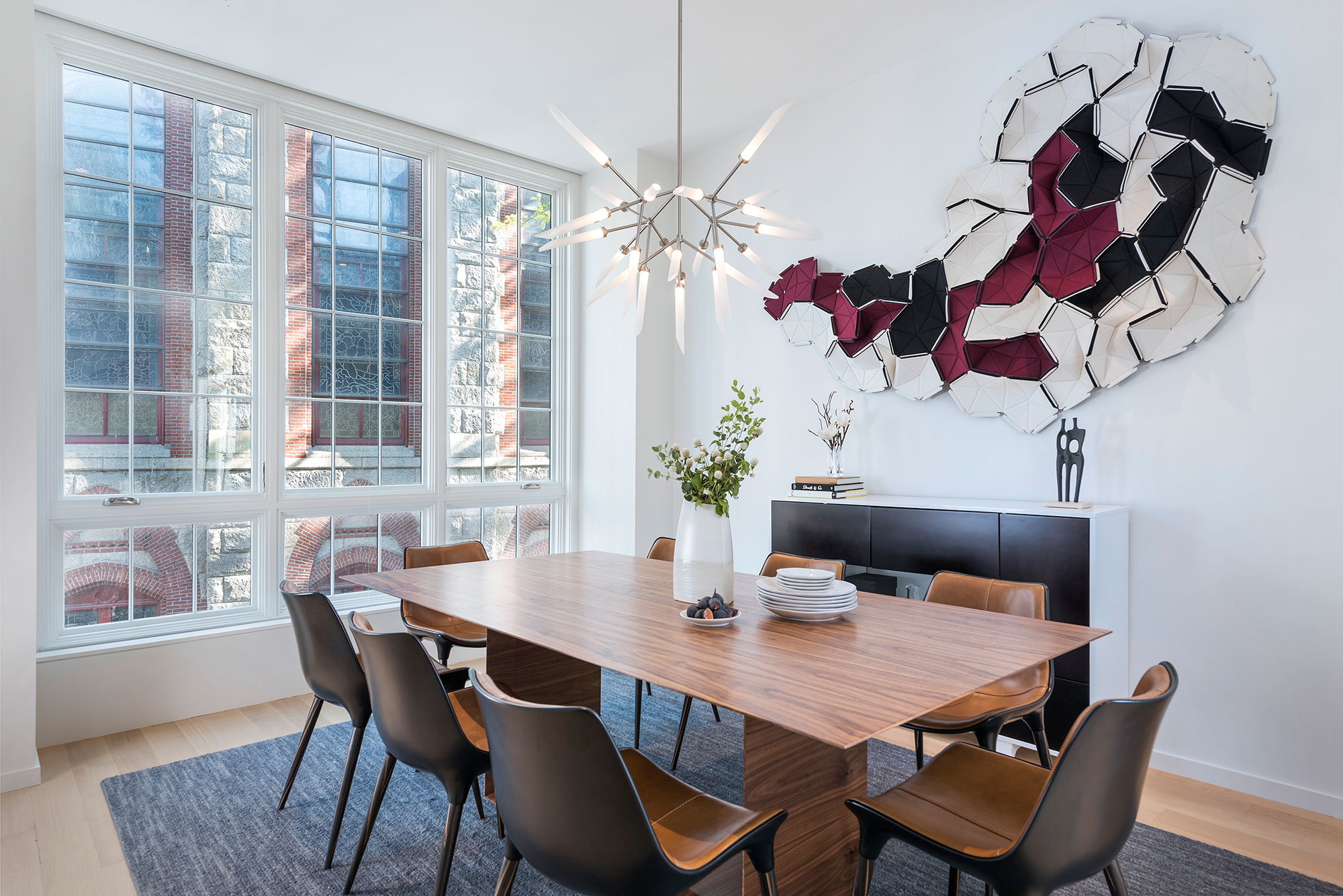 dining room with wall sculpture and modern chandelier