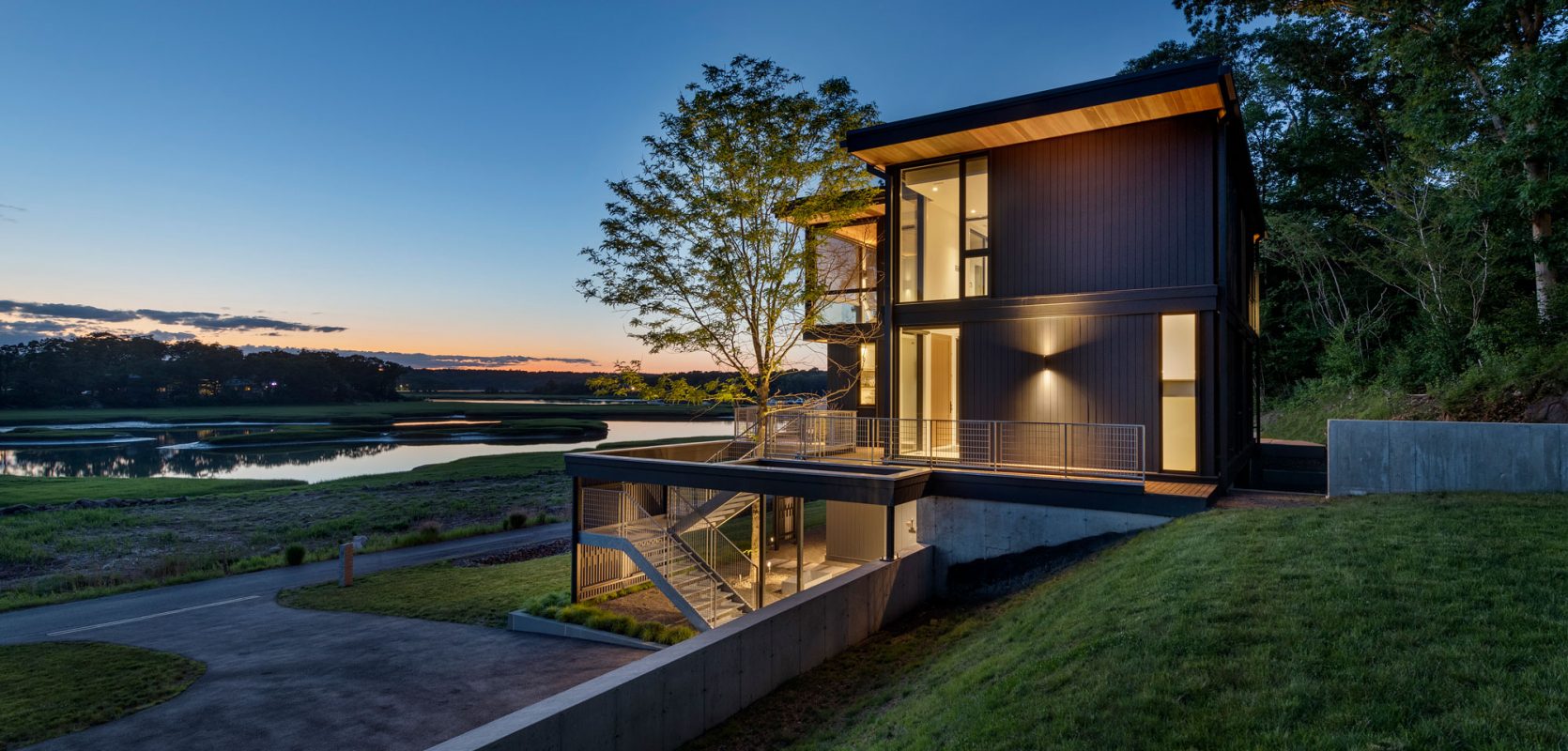 dusk shot of glowing home overlooking the marsh